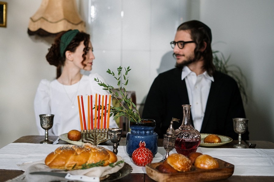 זוג דתי צעיר יושב לאכול ארוחת שבת ומסתכלים אחת לשני בעיניים