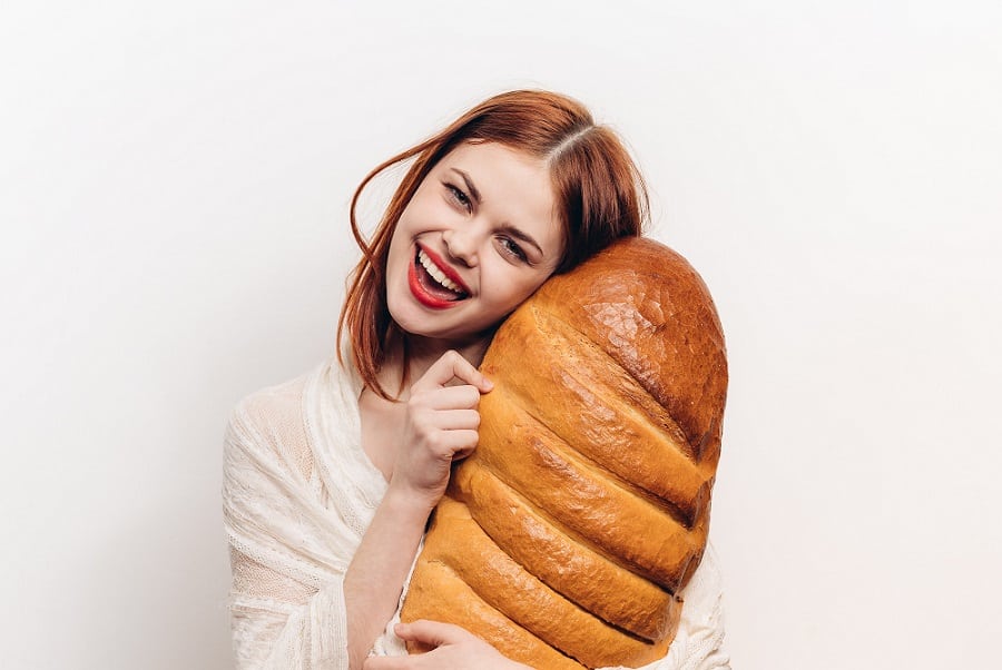 בחורה צעירה מחבקת כיכר ענקית של לחם
