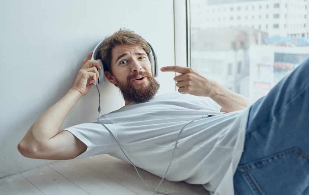 בחור עם ג'ינס שוכב מצביע על האוזן