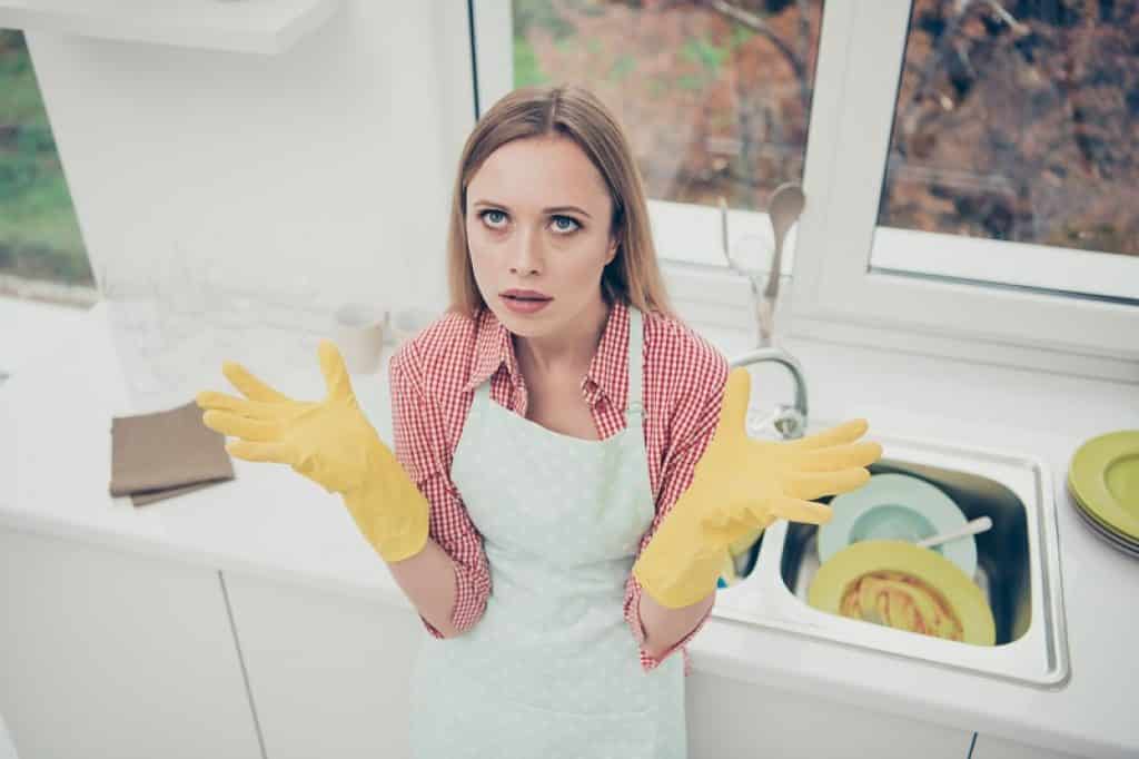 בחורה מתוסכלת מרוב כלים בכיור