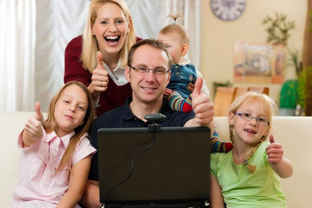 משפחה שמחה מול מחשב נייד ומצלמת רשת