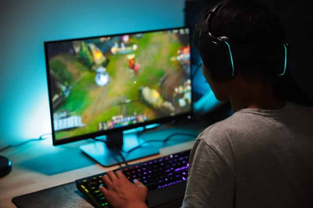 נער יושב מול מסך מחשב עם משחק אונליין פתוח