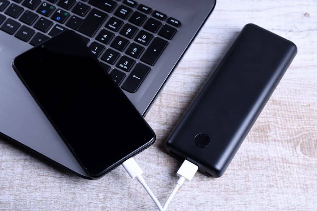 סוללת גיבוי וטלפון מונחים על שולחן מחשב
