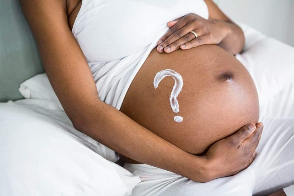 תמונה של בטן בהריון עם ציור של סימן שאלה