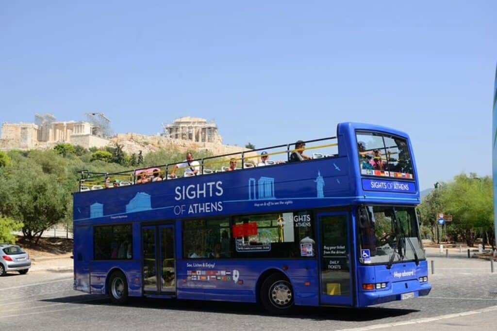 אוטובוס תיירים כחול דו קומתי וברקע האקרופוליס של אתונה