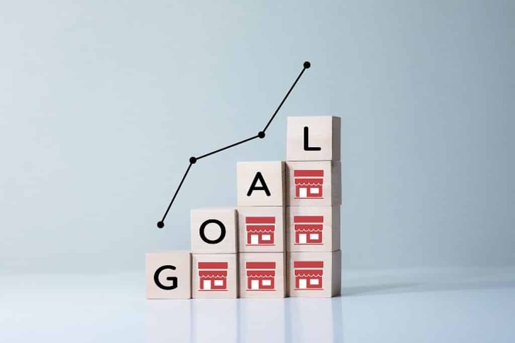 קוביות בדגם מדרגות עם המילה מטרה באנגלית ותמונה של חנות באדום גרף עולה