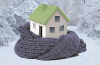 בית עם גג ירוק עטוף בצעיף אפור עם רקע שלג חורף