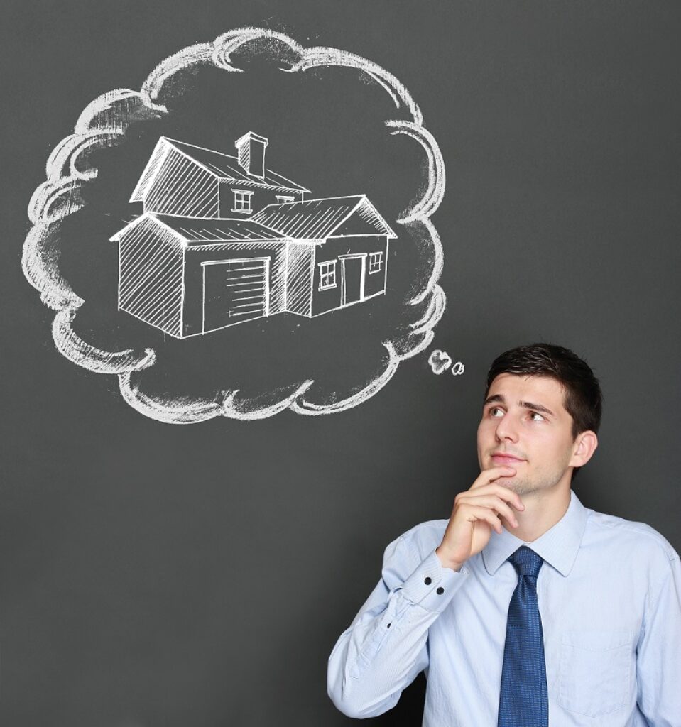 בחור בחולצה מכופתרת ועניבה חושב ולידו בועת מחשבה עם ציור של בית רקע אפור