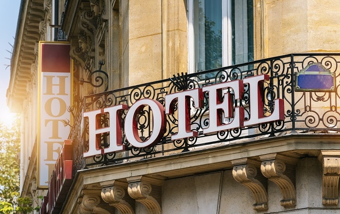 שלט עם המילה מלון באנגלית תלוי על מרפסת בפריז צרפת