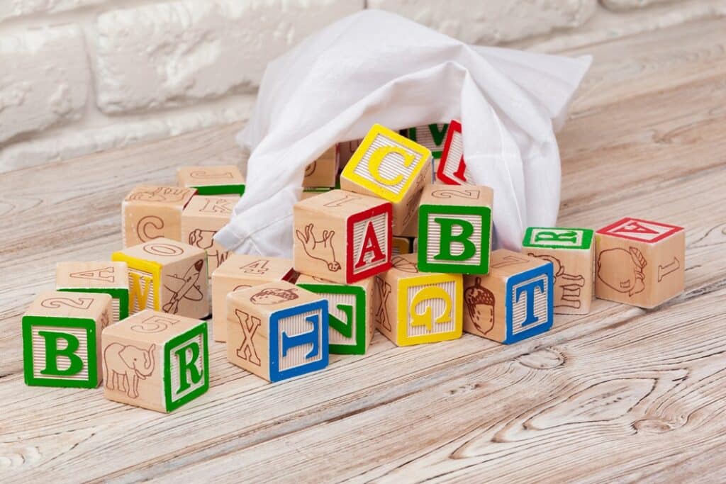 שק קוביות עם קוביות צבעוניות ואותיות באנגלית למשחק
